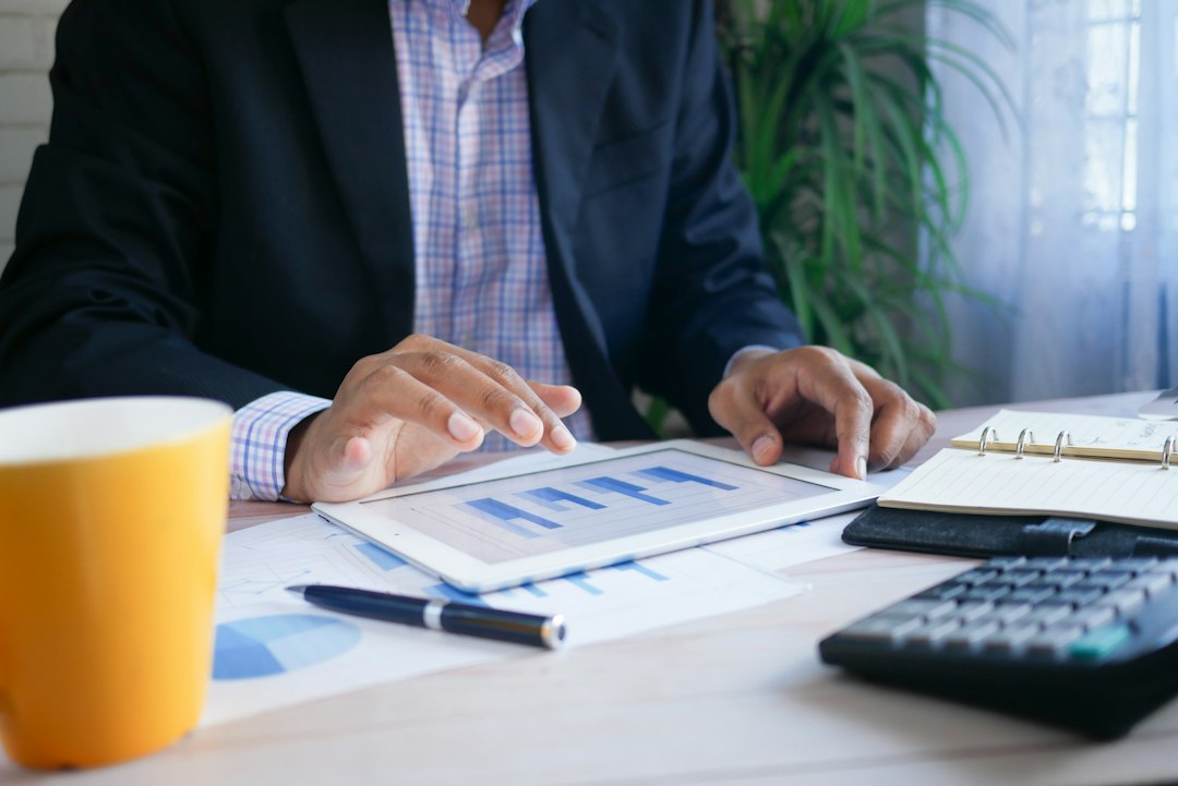 Person in a suit reviewing financial planning figures on a tablet